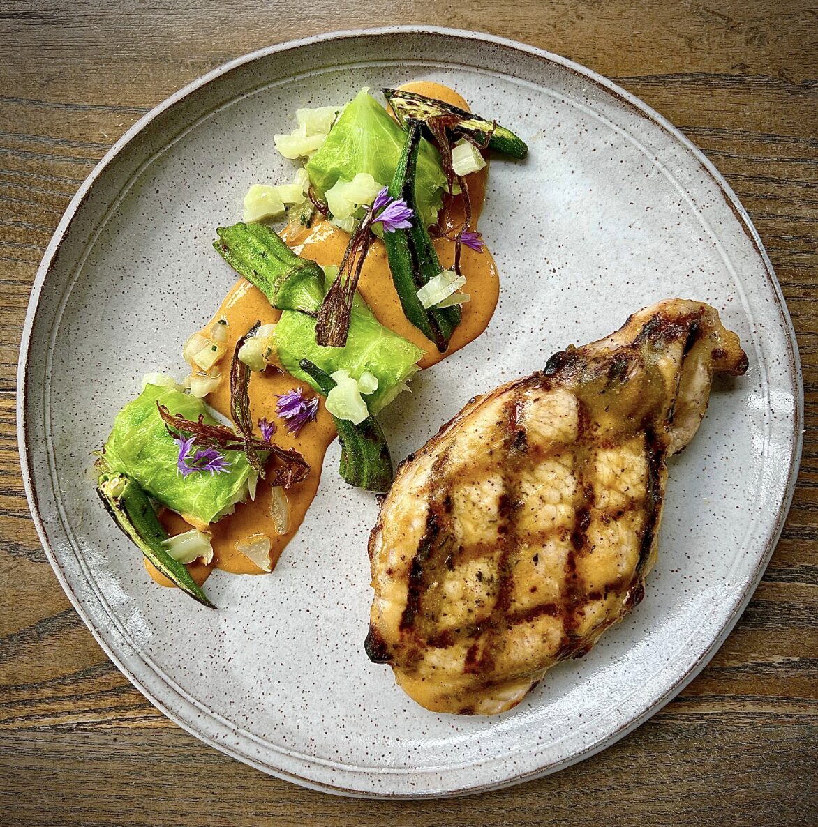 A plated grilled chicken with sautéed vegetables served at J.C. Holdway one of four tried and true Tennessee restaurants